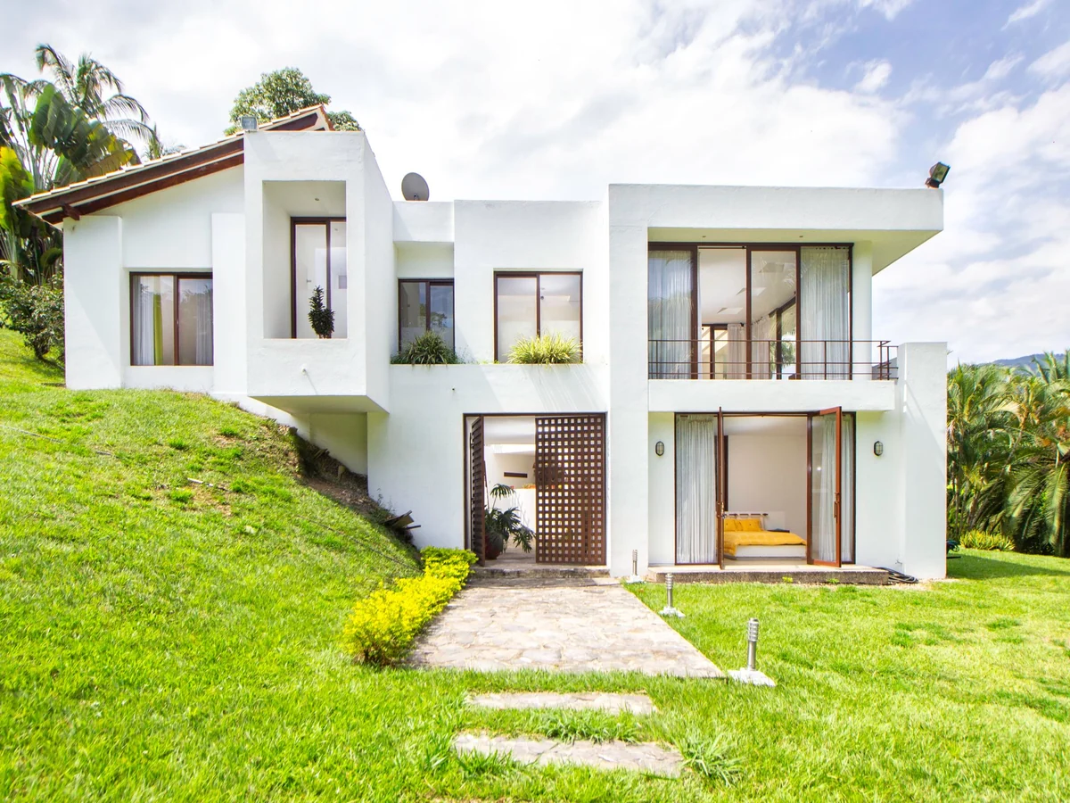 Contemporary white house set into a green hillside